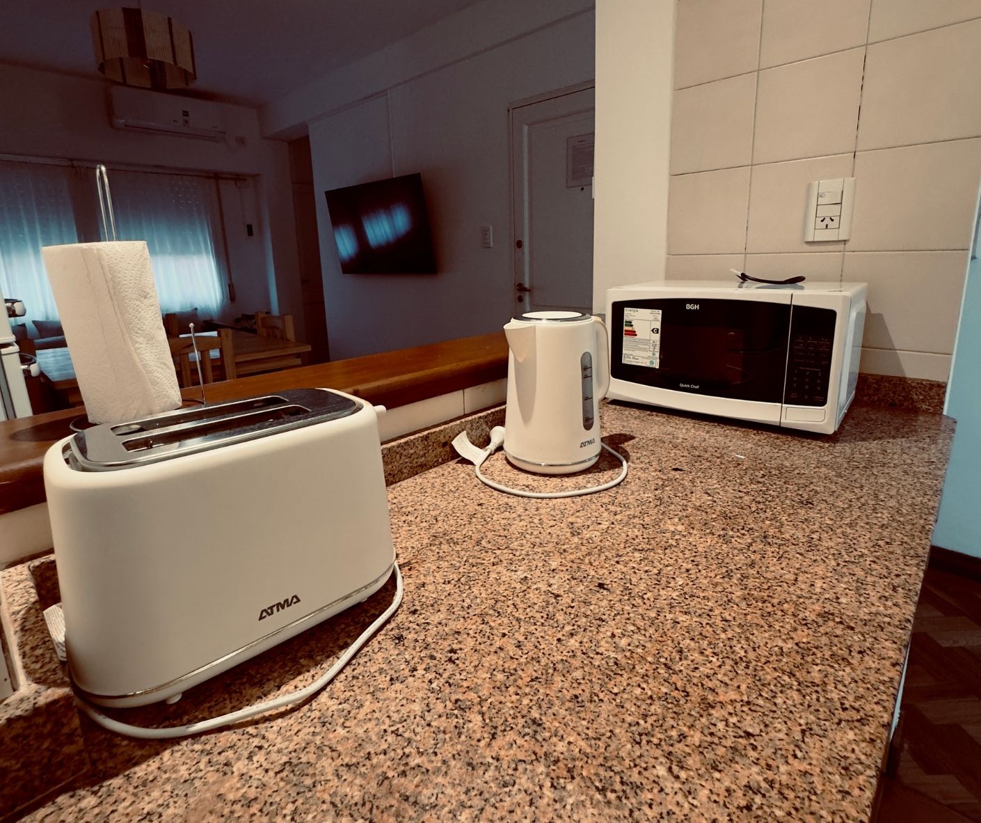 A toaster and a kettle are on a counter in a kitchen