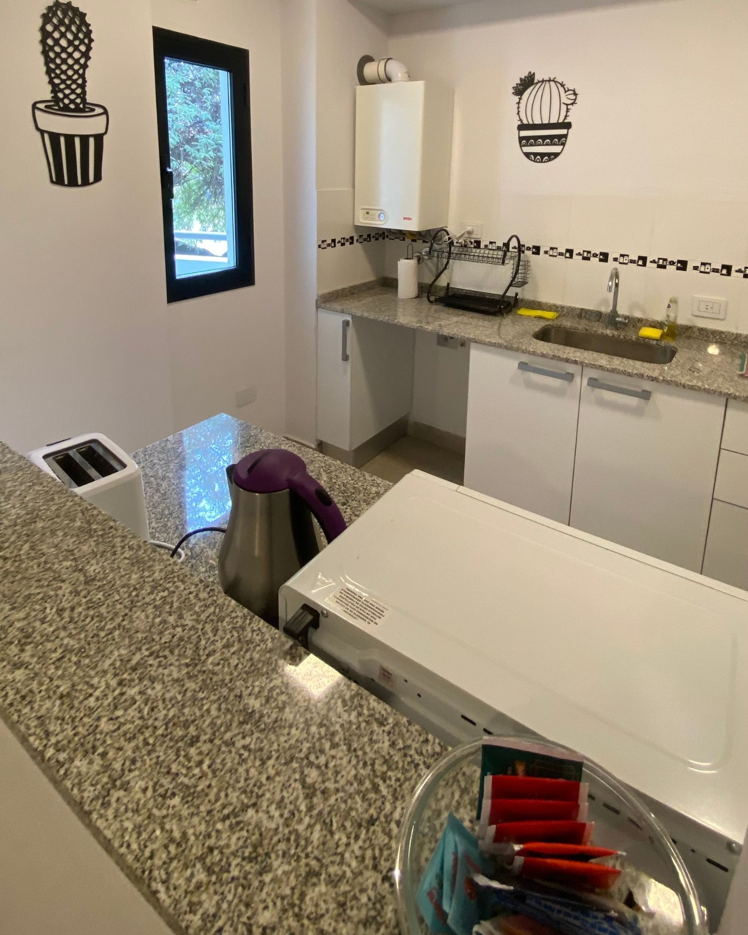 A kitchen with granite counter tops and white cabinets