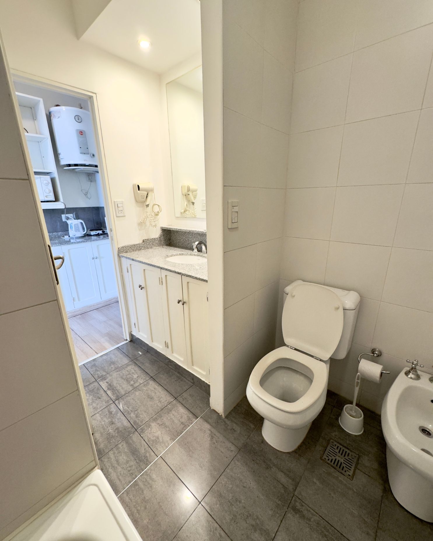 A bathroom with a toilet , sink and bidet.