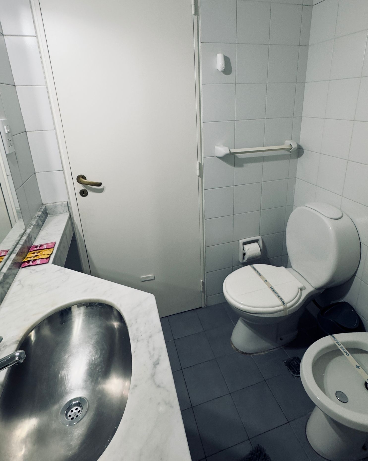A bathroom with a toilet a sink and a bidet