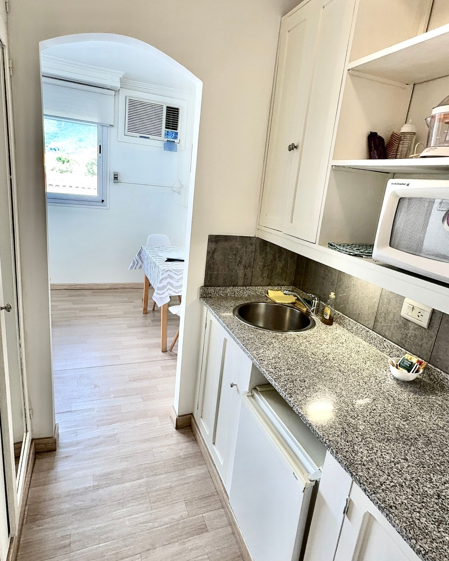 A kitchen with granite counter tops and white cabinets
