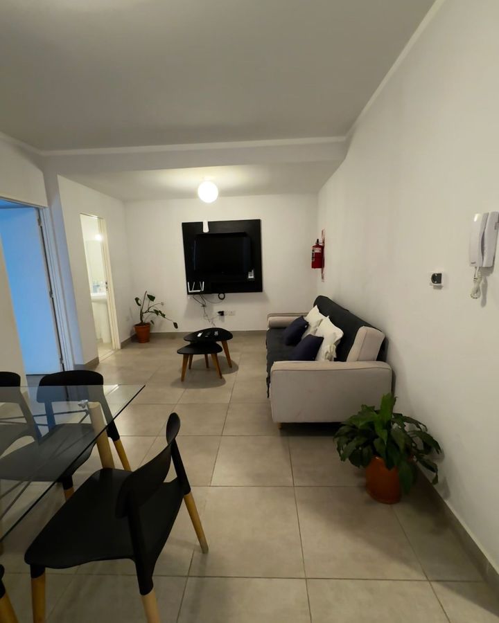 A living room with a couch and a tv on the wall