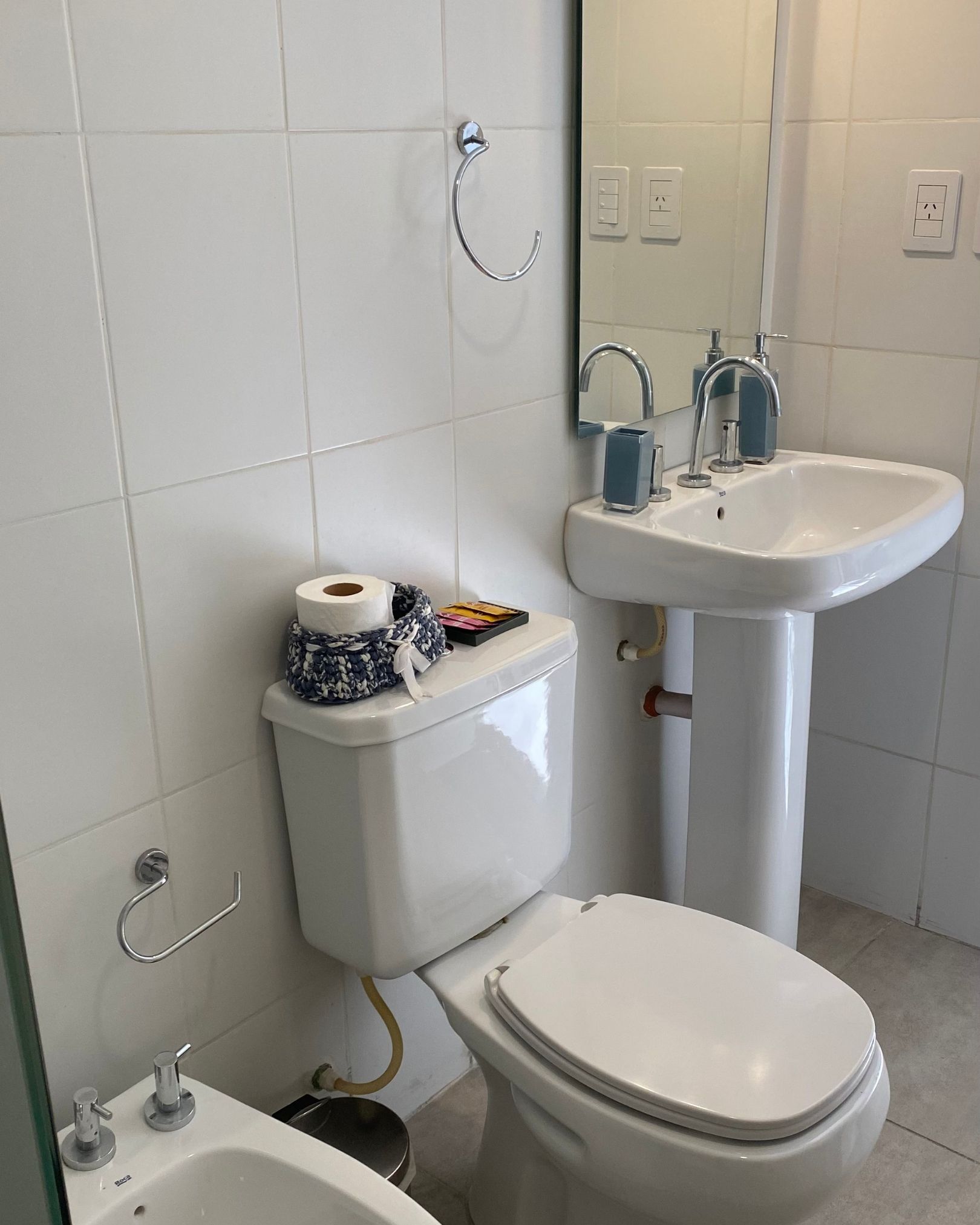 A bathroom with a toilet , sink and bidet