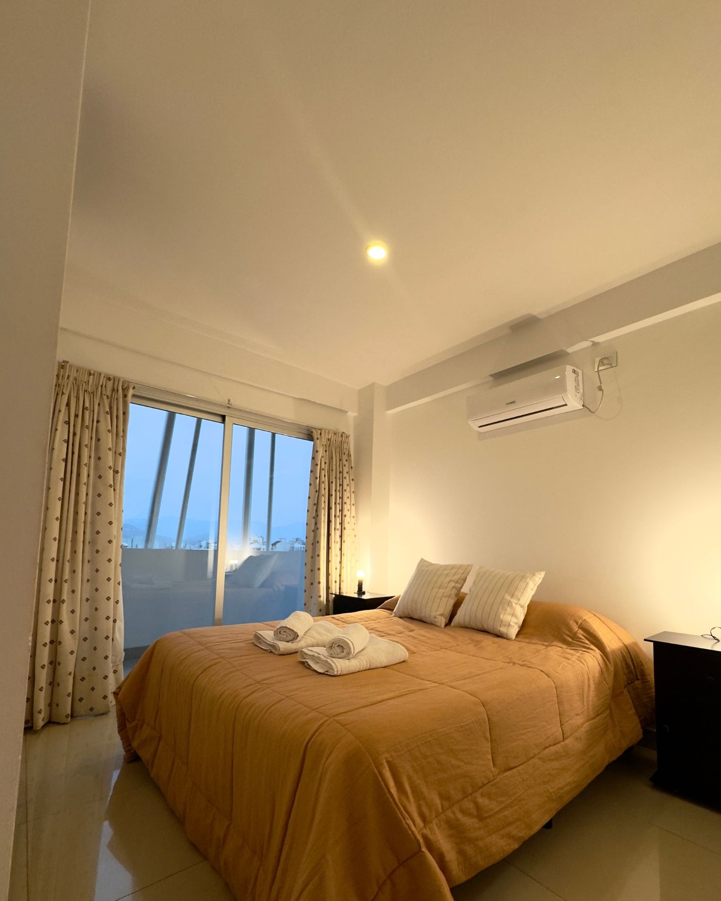 A bedroom with a large bed and a window