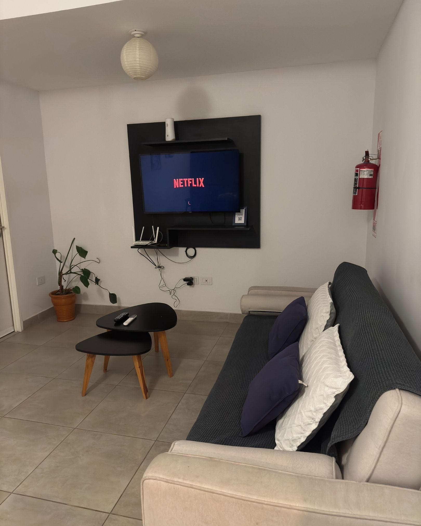 A living room with a couch and a tv that says netflix on it