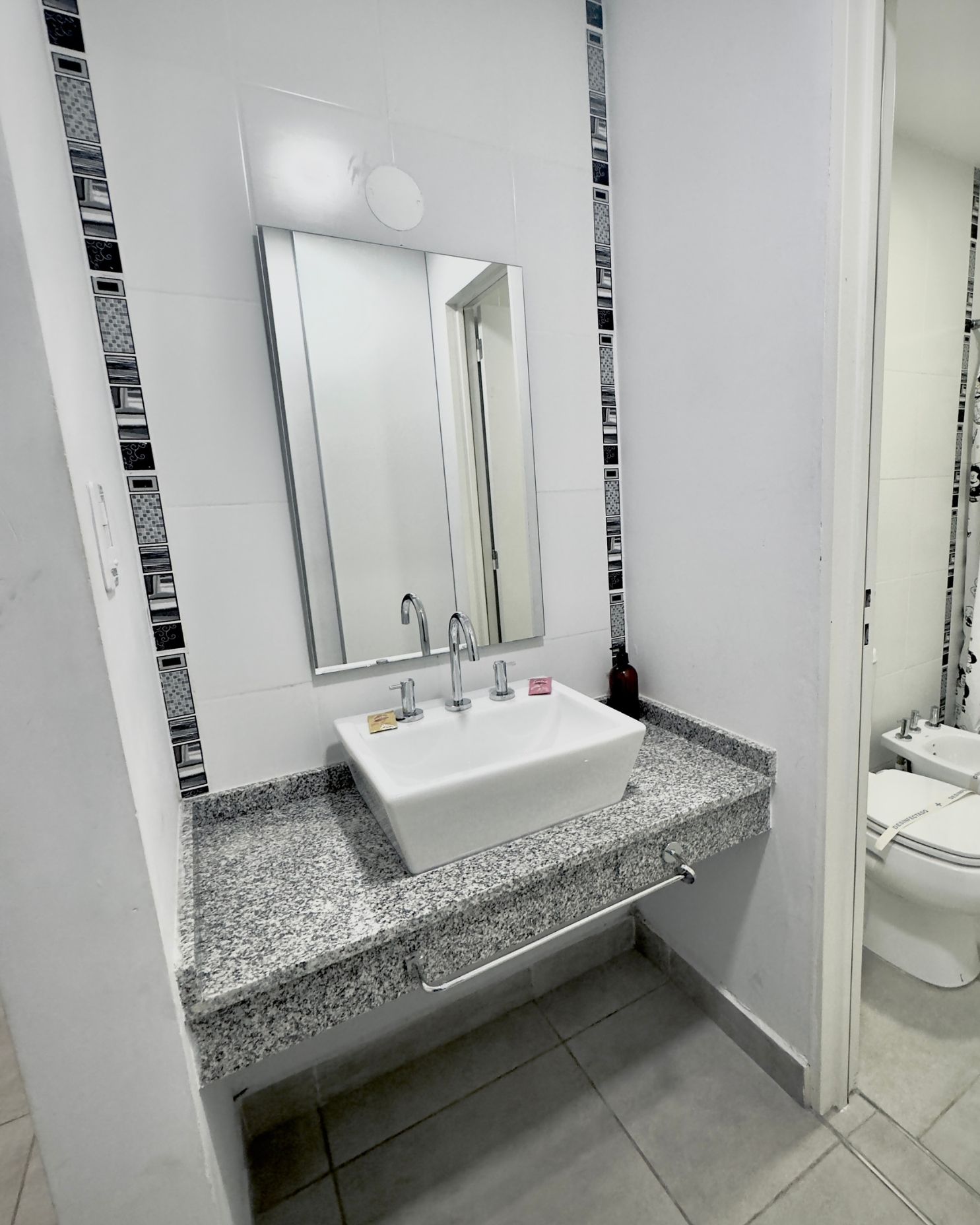 A bathroom with a sink , mirror and toilet.