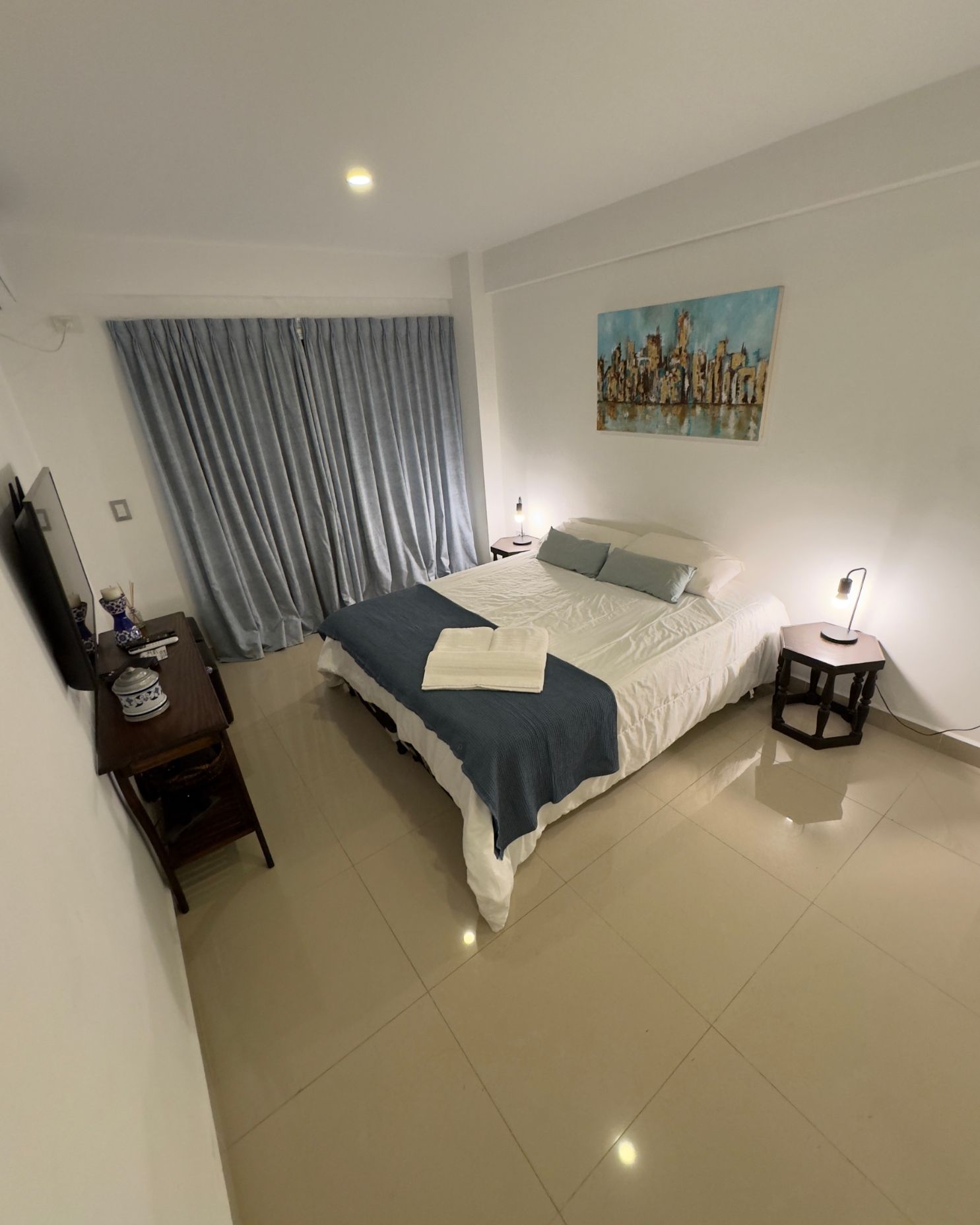 A bedroom with a bed , nightstand , and television.