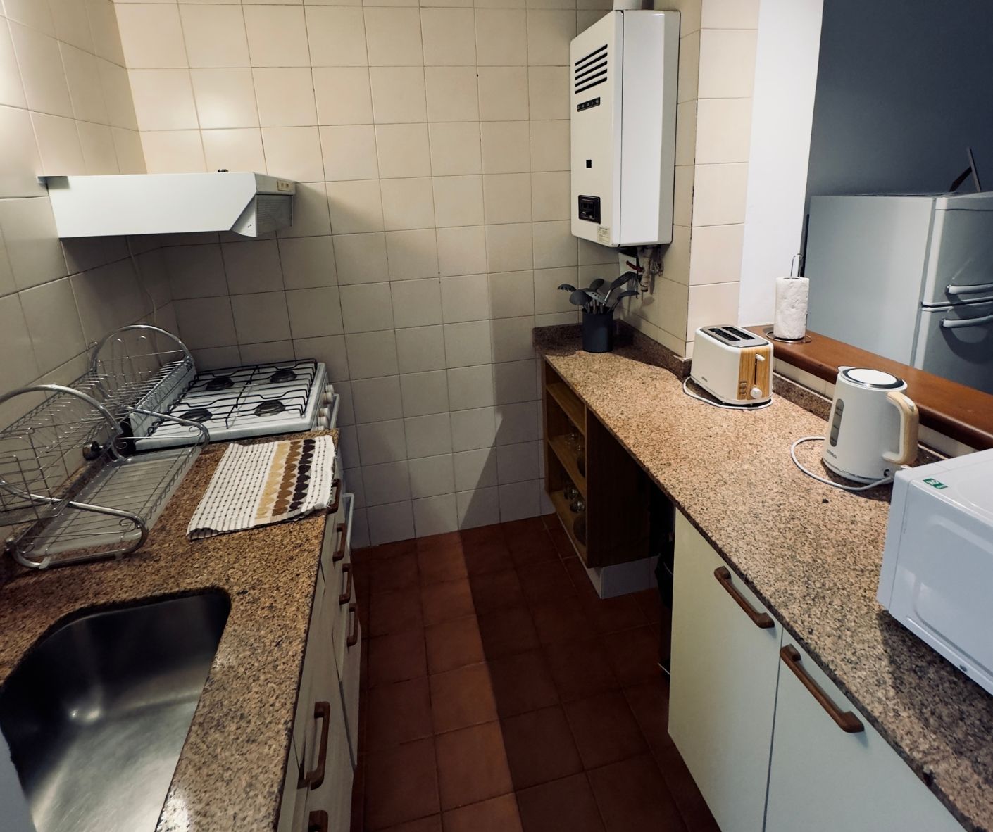 A kitchen with a sink stove and toaster oven