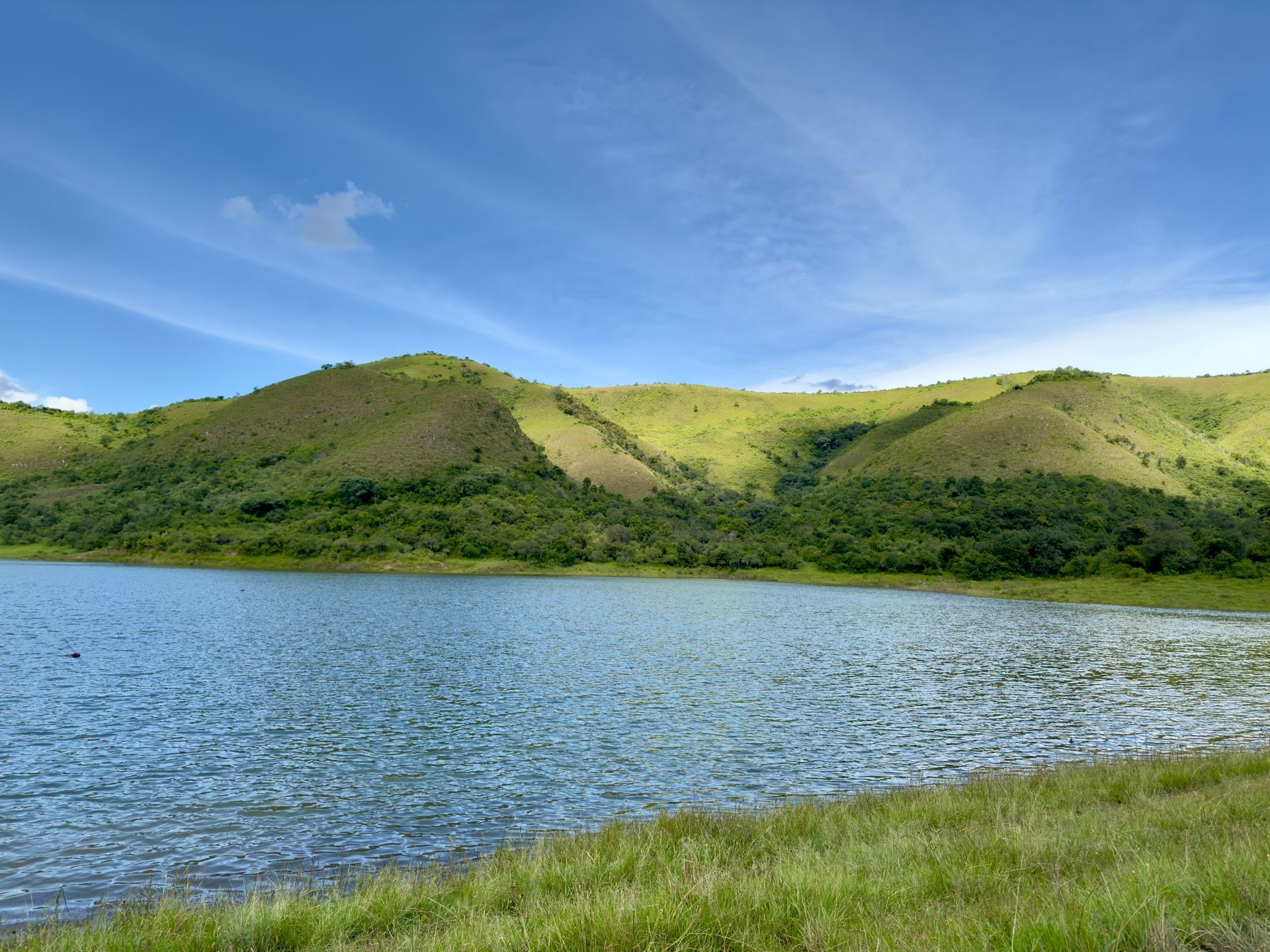 A lake with mountains in the background on a sunny day
