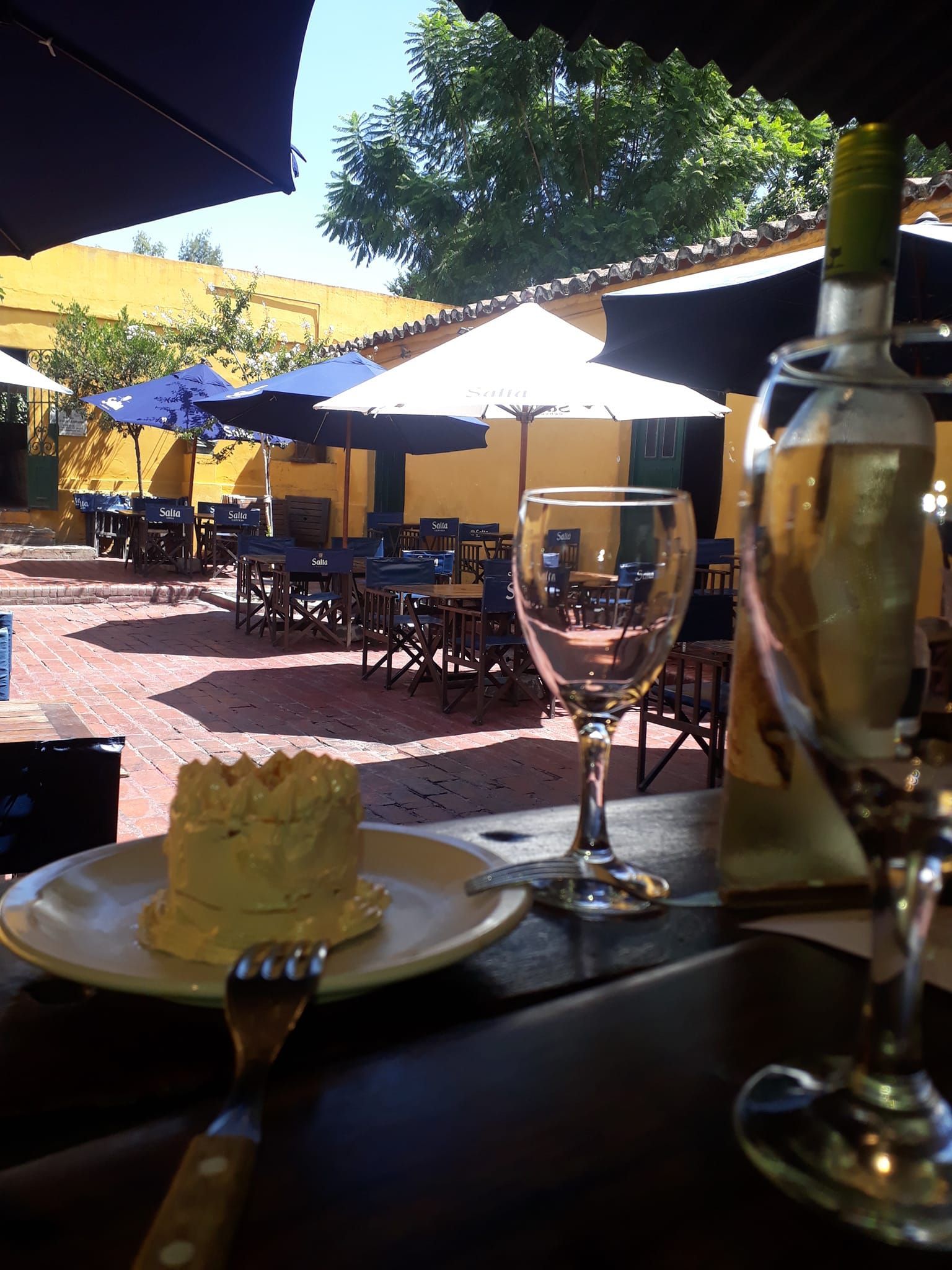 A plate of food sits on a table next to a glass of wine