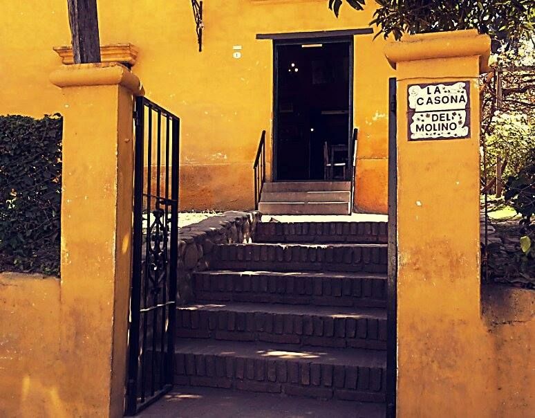 A yellow building with stairs and a sign that says la carona