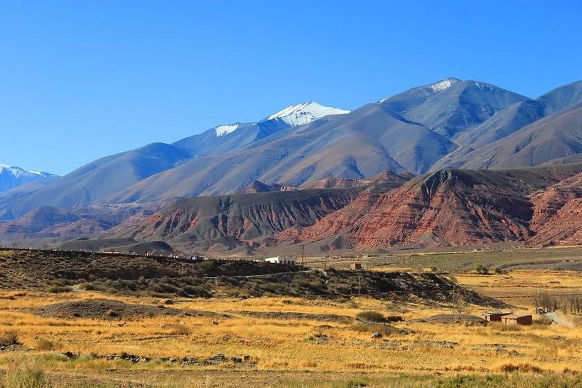 A landscape with mountains in the background and a field in the foreground