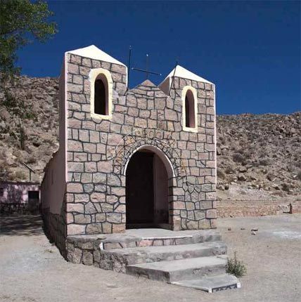 A small stone building with stairs leading up to it