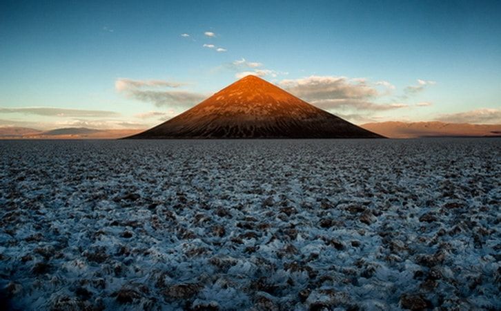 There is a mountain in the middle of a field.