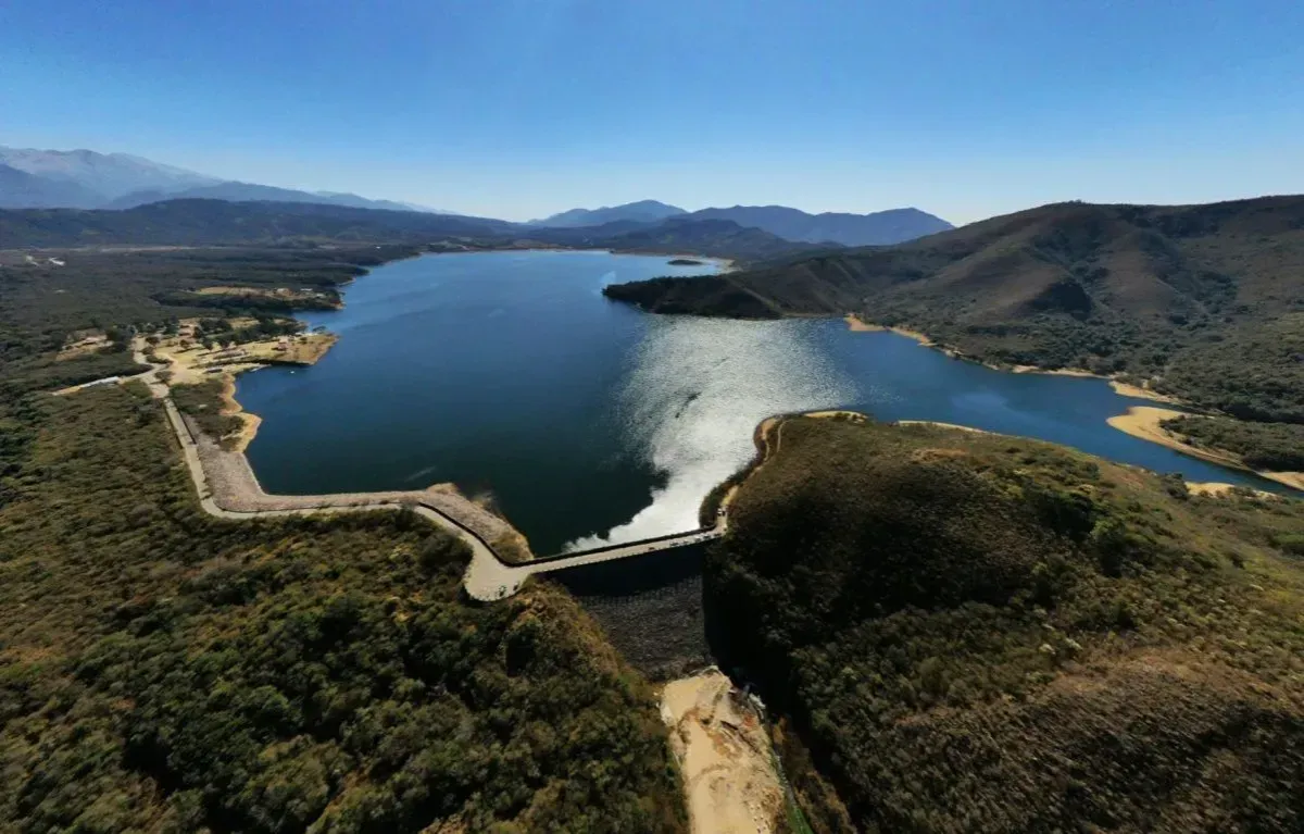 An aerial view of a large lake with mountains in the background