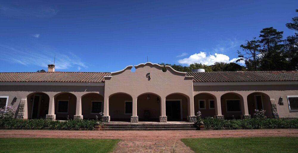 A large building with arches and a blue sky in the background