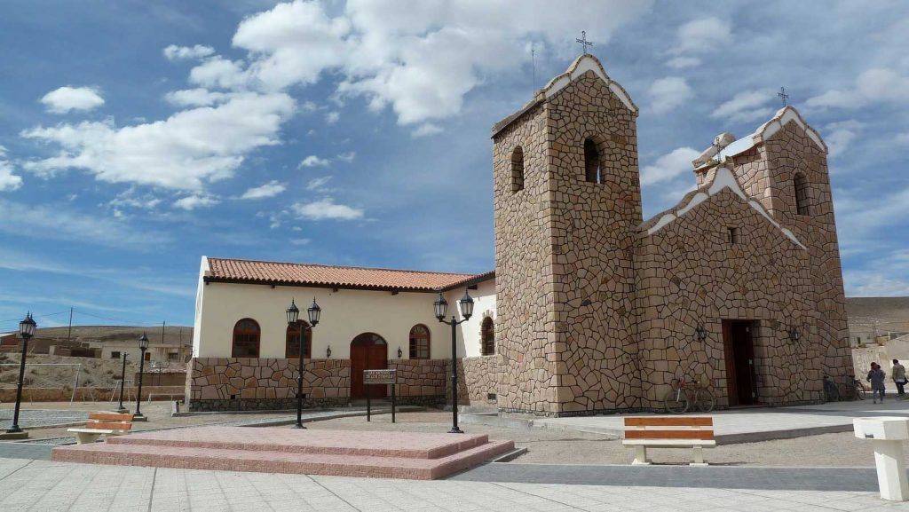 A church with two towers and a bench in front of it