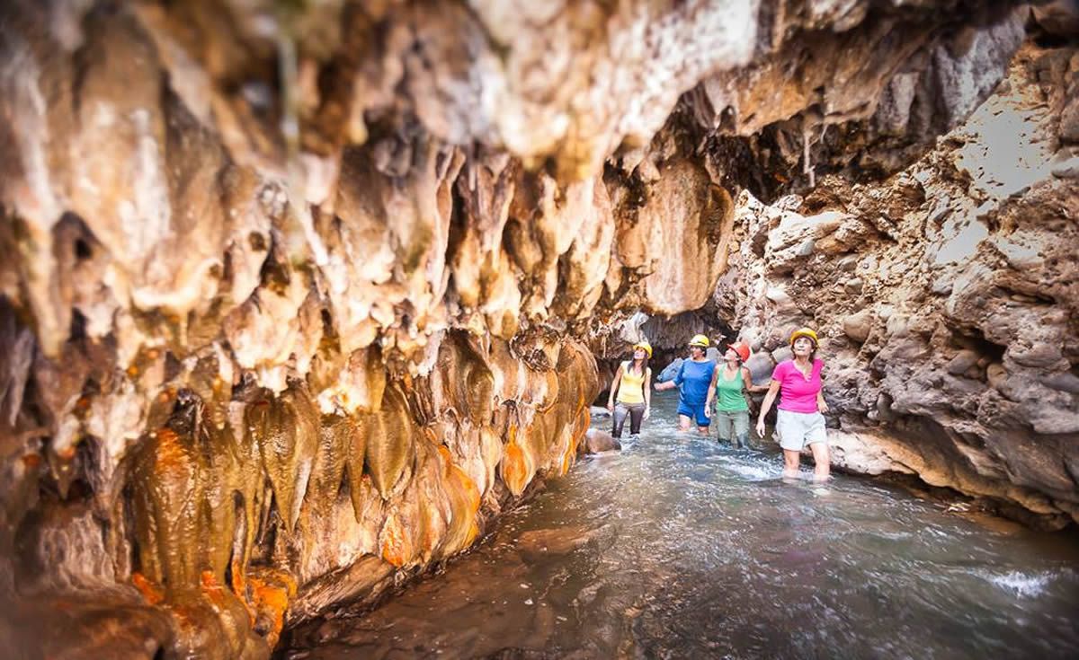 A group of people are walking through a cave.