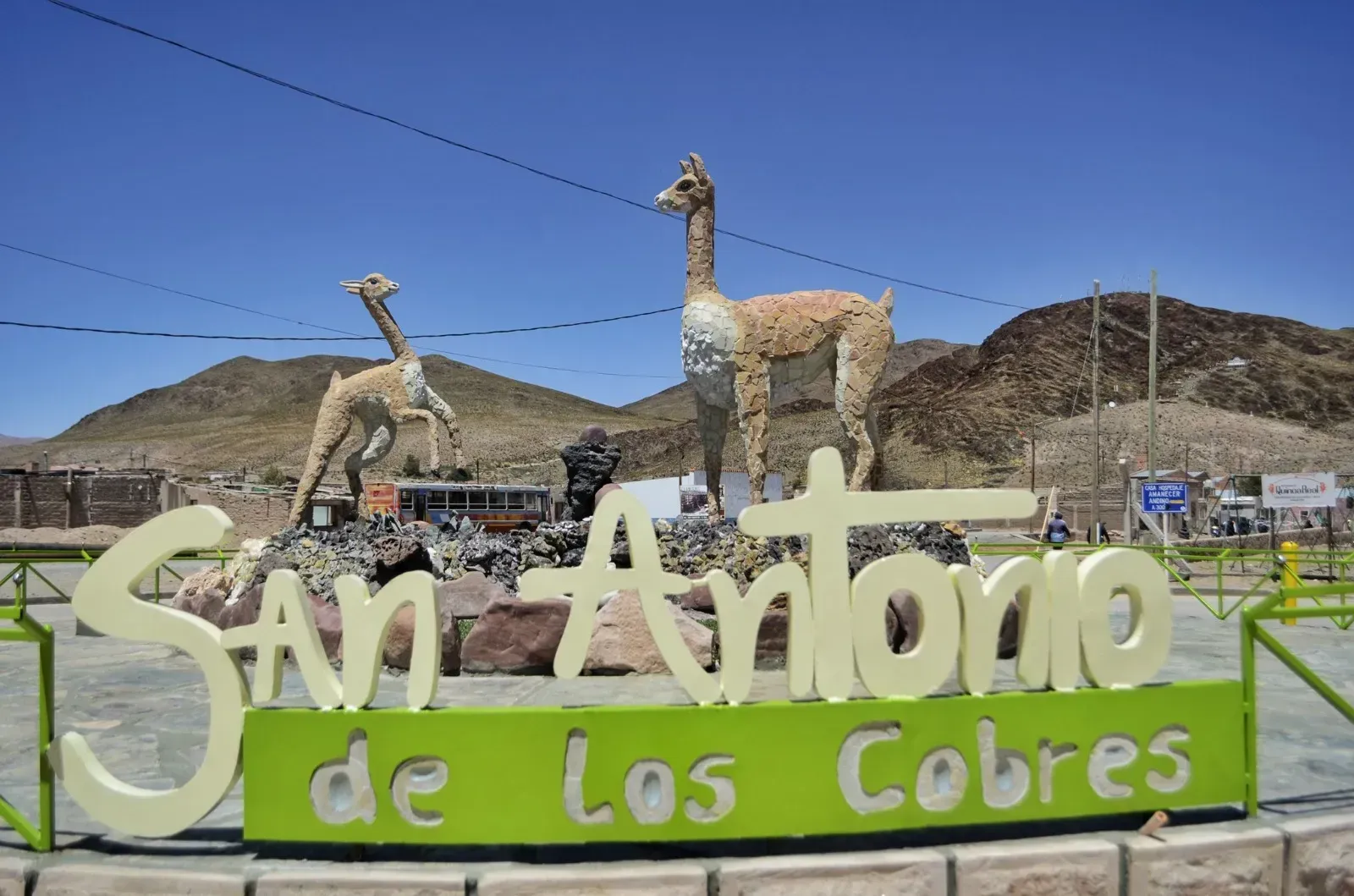 A green sign that says san antonio de los cobres