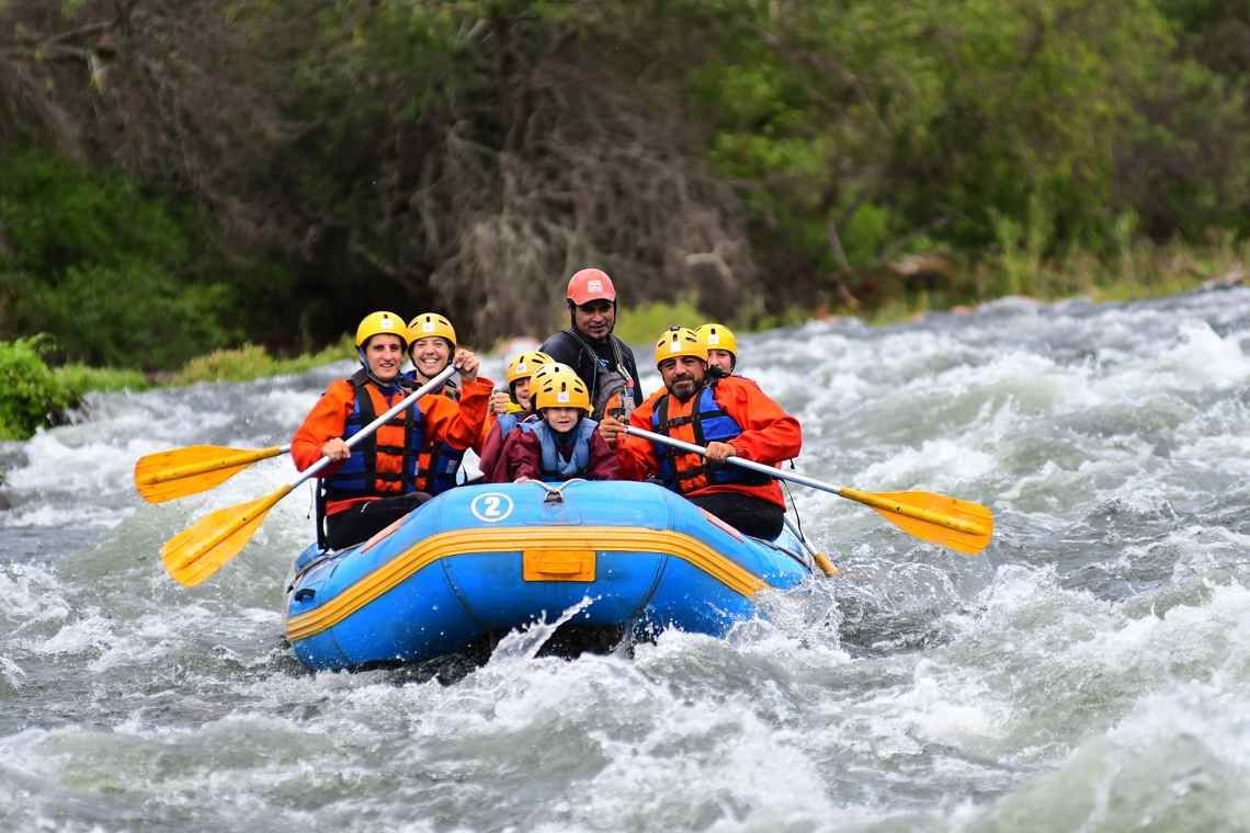 A group of people are rafting down a river in a raft.