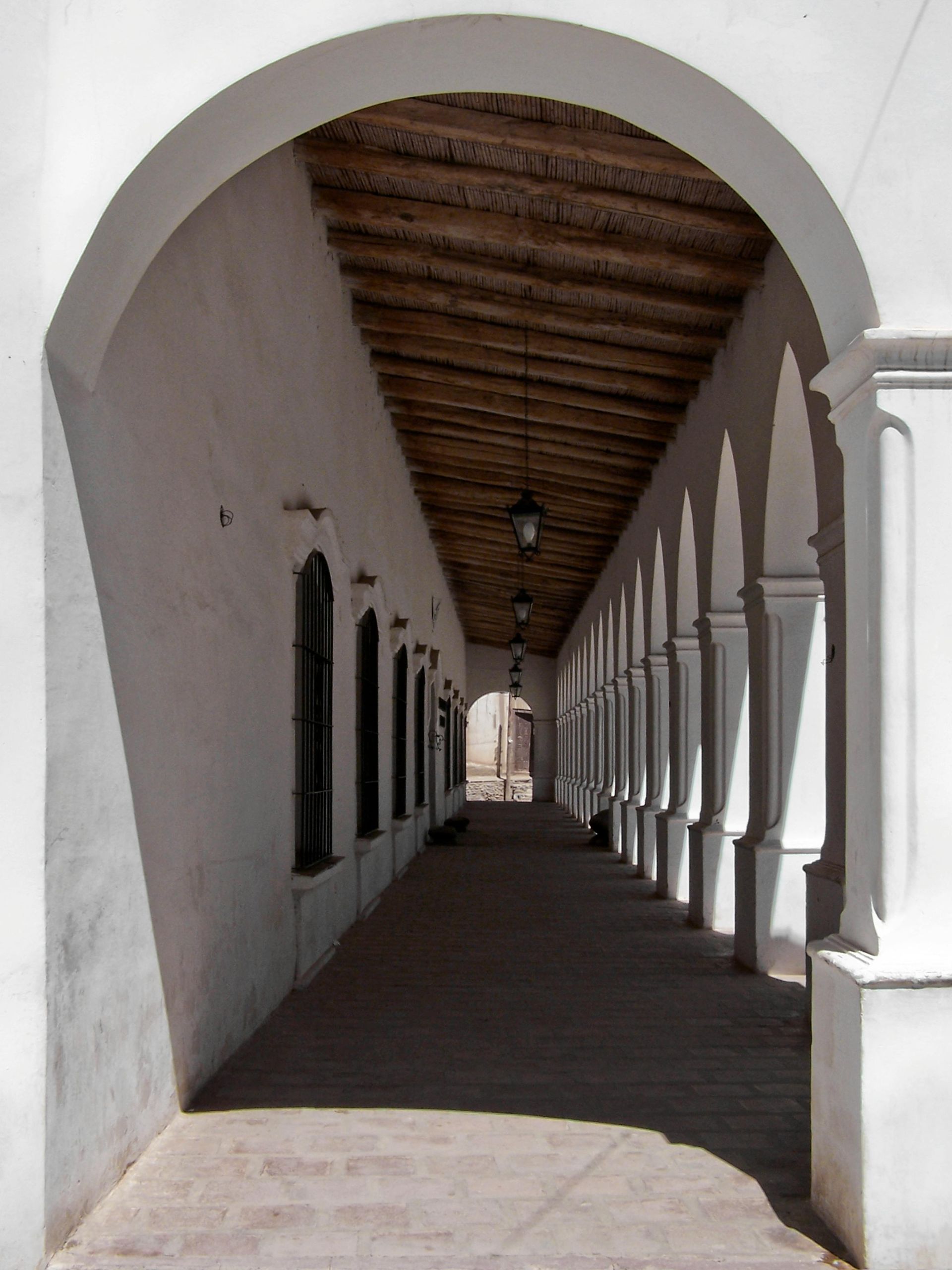 A long white hallway with arches and columns