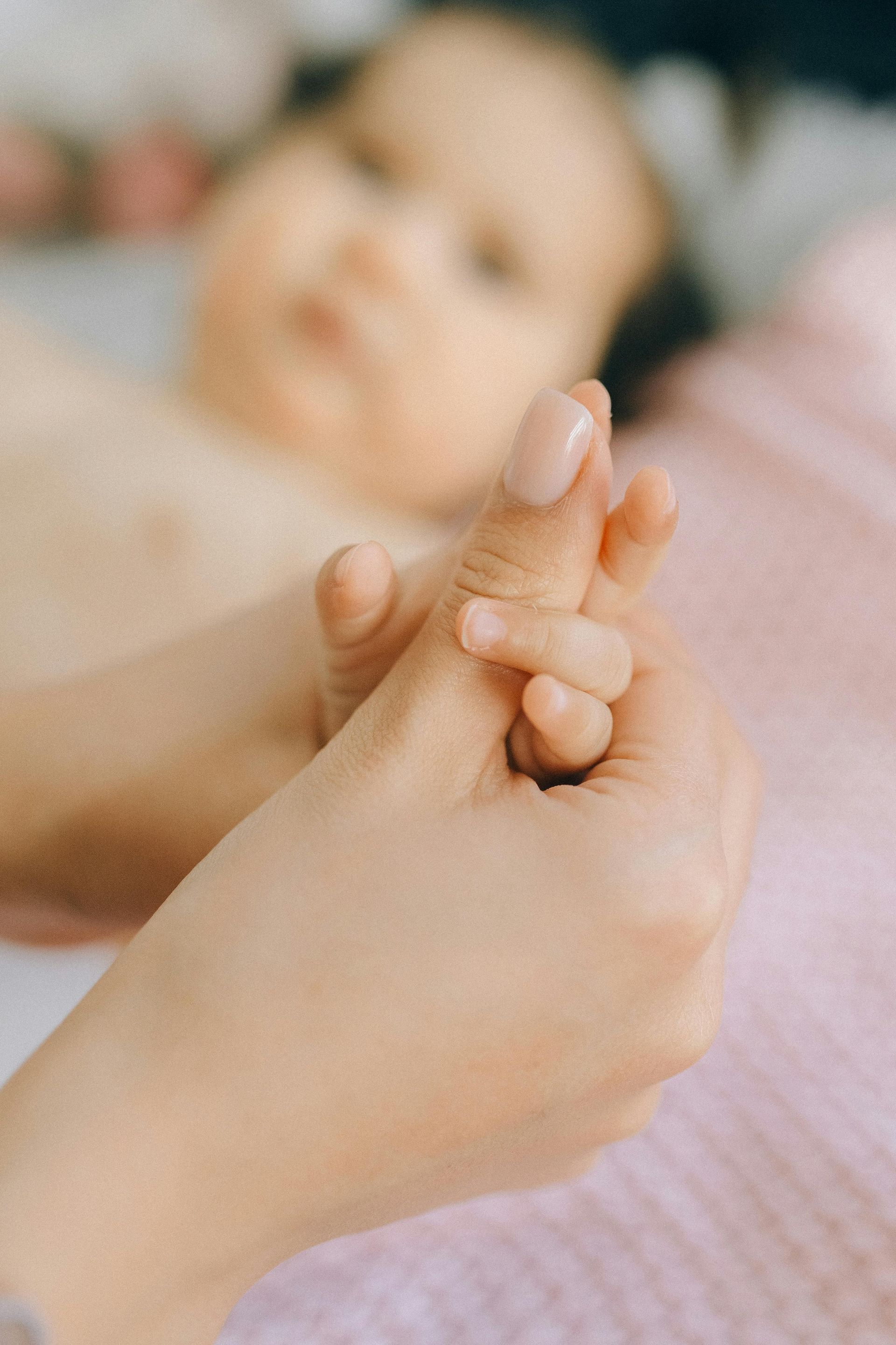 Babymassage, Hand die de kleine vingertjes van een baby vasthoudt