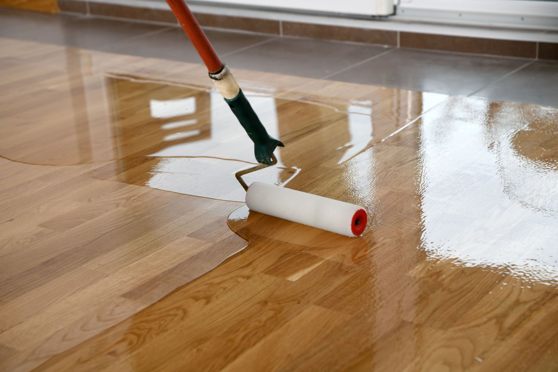 lacquering wood floors worker uses roller
