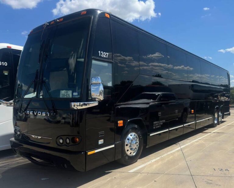 A black bus is parked in a parking lot on a sunny day.