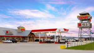 A gas station with cars parked in front of it.