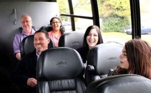 A group of people are sitting on the back of a bus.