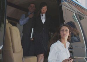 A man and two women are boarding a private jet.