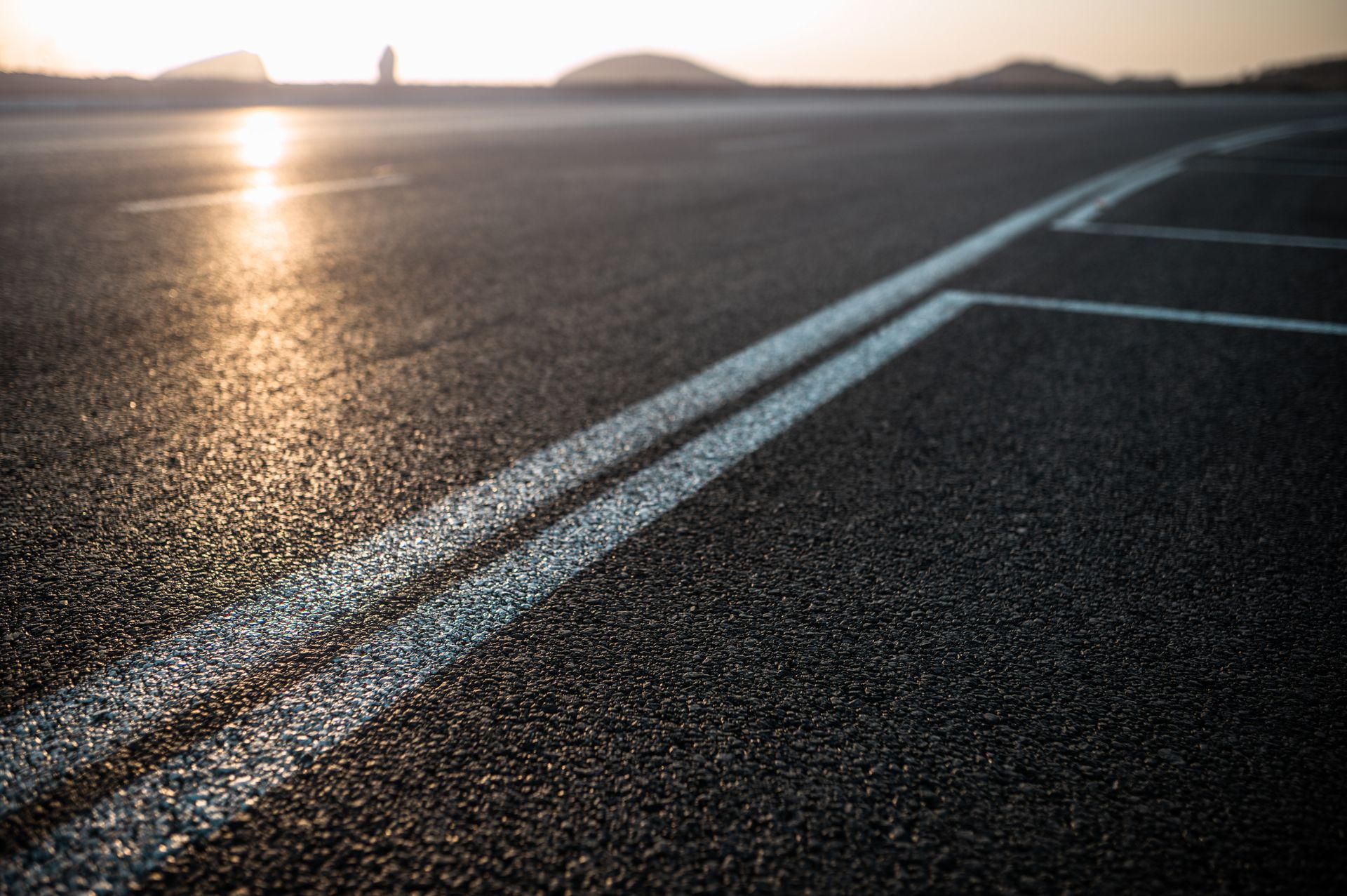 A close up of a road with two white lines on it