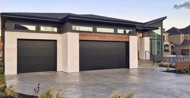 modern home with two black garage doors