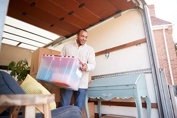 man unloading boxes from moving truck