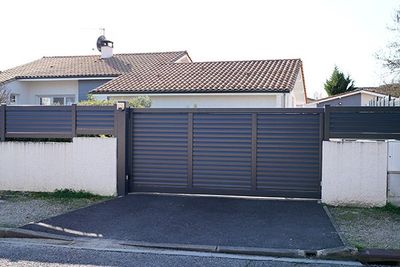 house with black metal gate and fence