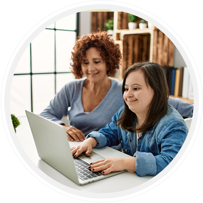 two people in front of a laptop