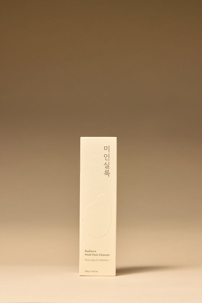 奶油色的洗面乳管上印有中文和韓文文字，聲稱可以清潔、去角質和滋潤皮膚。