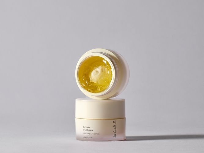 兩個奶油色的小護膚品罐。其中一個打開了，裡面是黃色的凝膠。