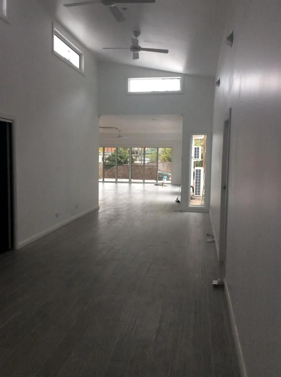 An Empty Room with A Lot of Windows and A Ceiling Fan — All Trade Renovations- Peter Whelan in Mannering Park, NSW