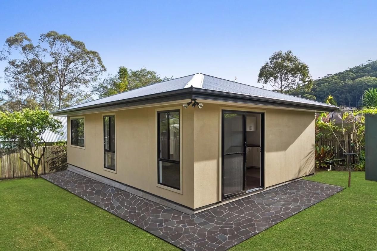A Small House Is Sitting on Top of A Lush Green Lawn — All Trade Renovations- Peter Whelan in Lake Macquarie, NSW