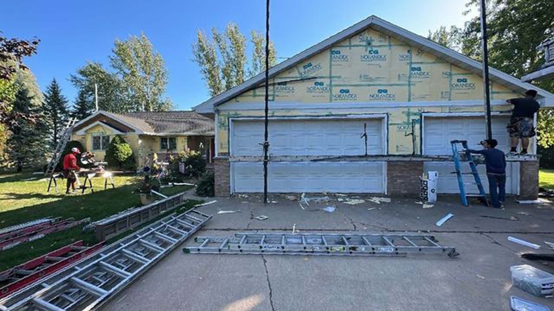 A house is being remodeled with a ladder in front of it.