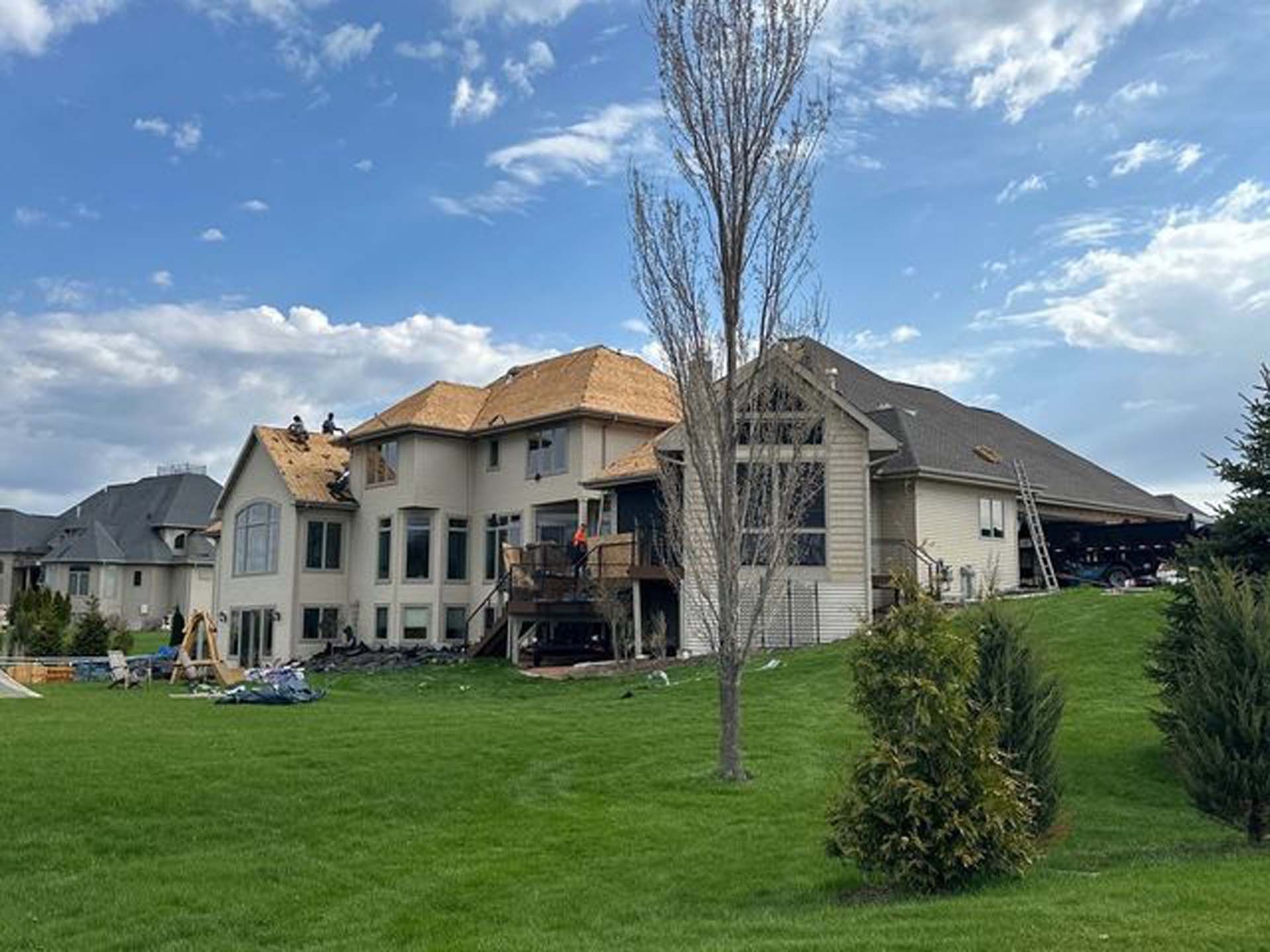 A large house is sitting on top of a lush green hill.