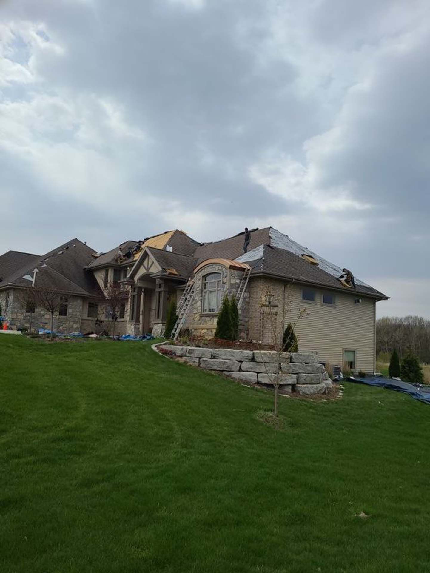 A large house is being remodeled with a roof being installed.