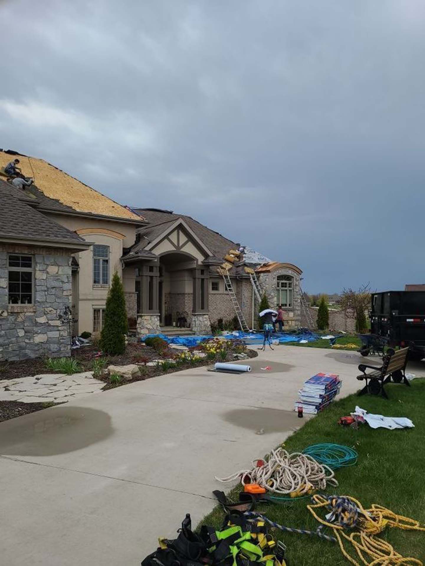 A large house is being remodeled with a roof being installed.