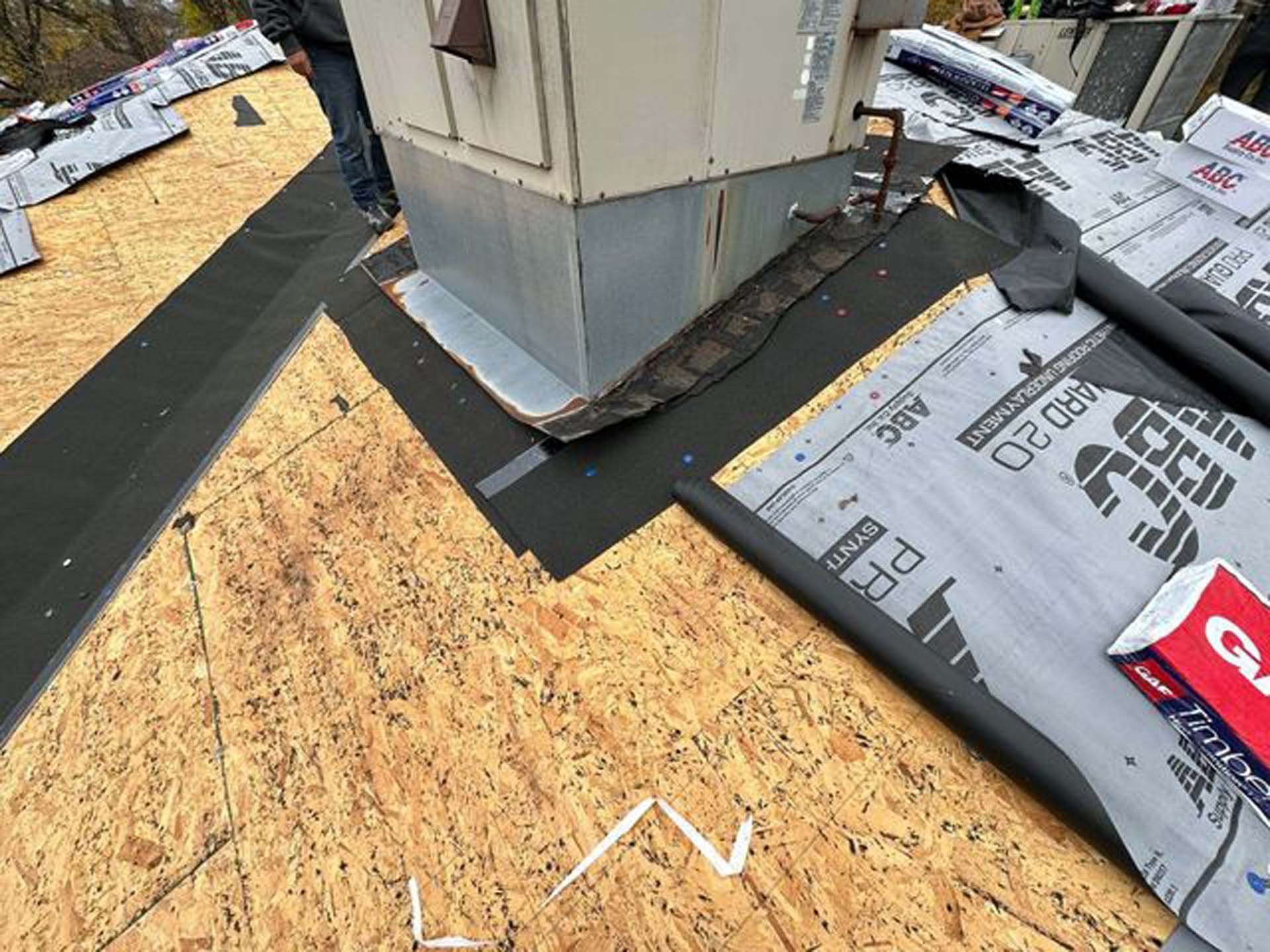 A roof is being installed on a building with a chimney.