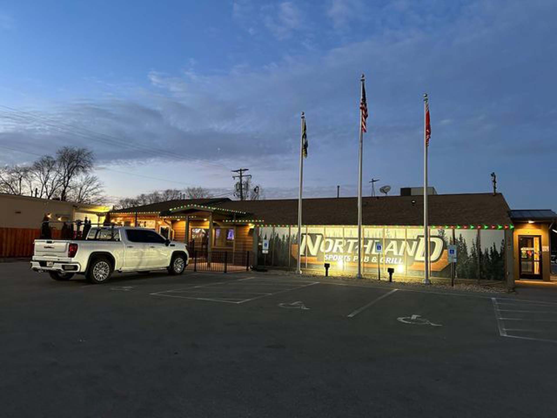 A white truck is parked in front of a building.