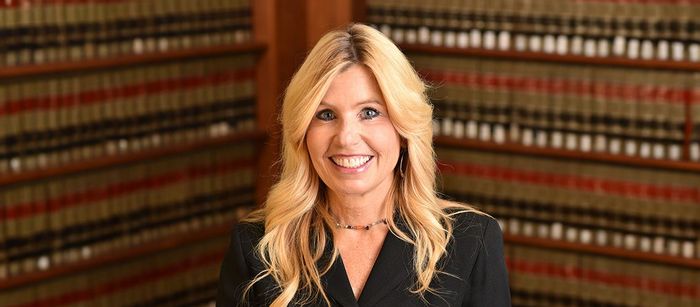 Diane Birnholz, Former Federal Prosecutor stands in a legal library