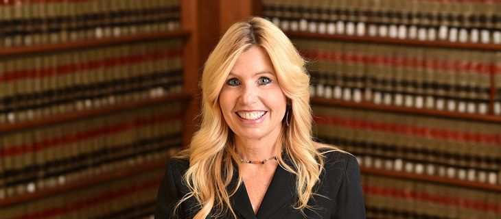 Diane Birnholz, Former Federal Prosecutor stands in a legal library