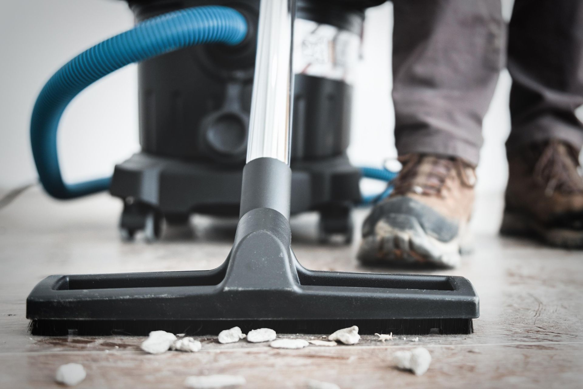 A person is using a vacuum cleaner to clean the floor.