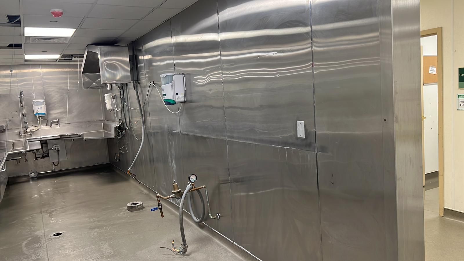 A kitchen with stainless steel walls and a sink.